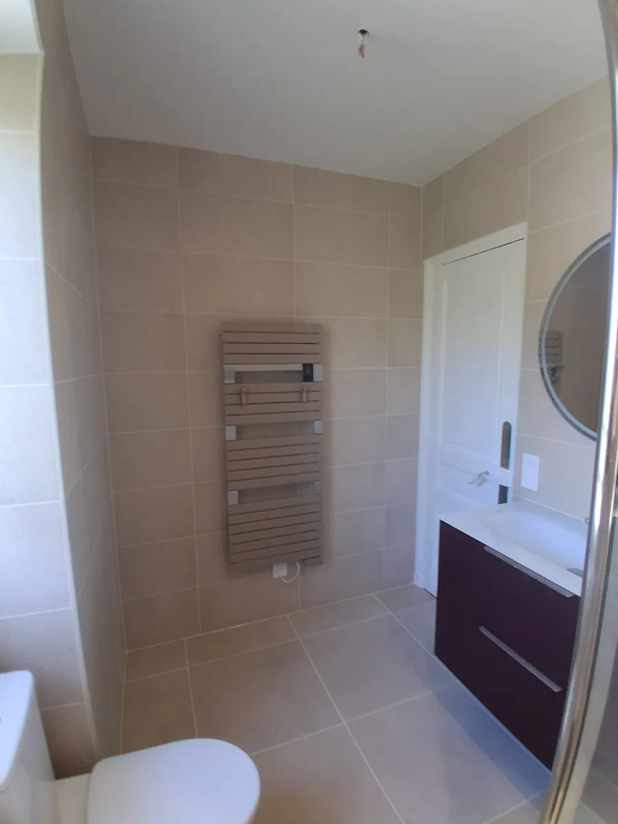 Carrelage grand format beige pose dans une salle de bain en Essonne